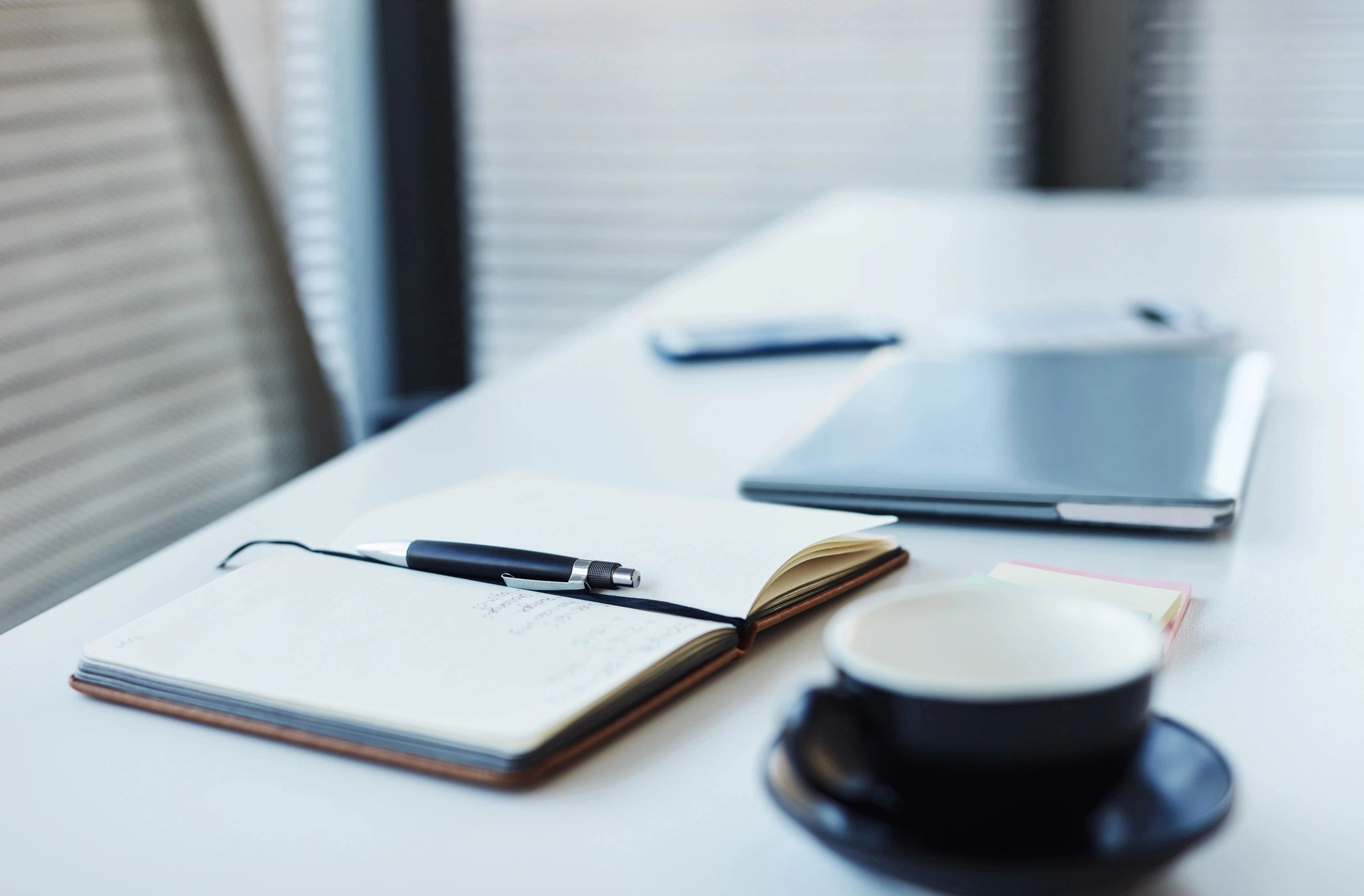 Notebook and laptop on a desk in a calm modern workspace